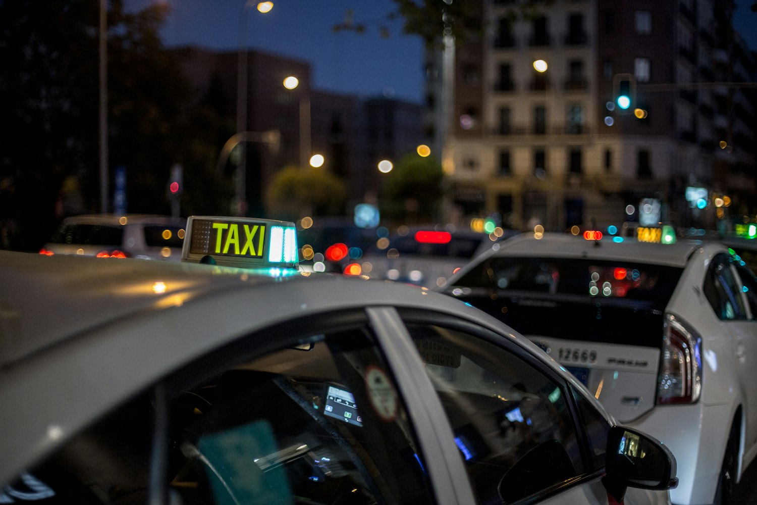 Taxi's onderweg in een straat bij nacht